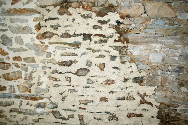 Mur de pierre en cours de rejointoiement à la chaux