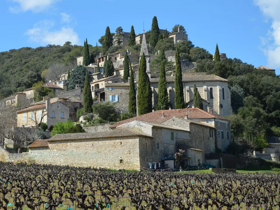 Village de pierre à flanc de colline au-dessus des vignes